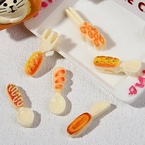 Detailed macro view of miniature resin cutlery set featuring croissant and baguette handles