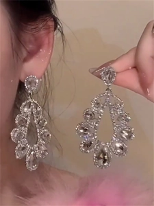 Macro shot of silver drop earrings featuring sparkling rhinestones in a hollow design