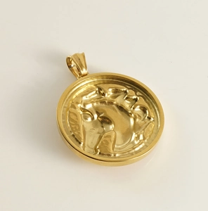 Detailed macro view of 18k gold horse head relief on round stainless steel pendant