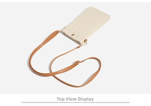 Detail shot of woven straw texture and adjustable brown faux leather strap with gold buckles