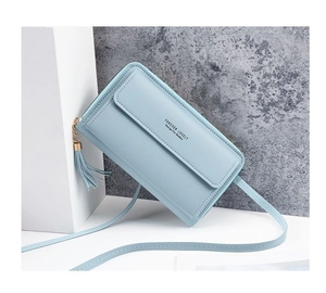 Detail of light blue crossbody phone bag with tassel zipper and minimalist gold lettering