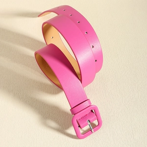 Close-up of rose pink leather waist belt with matching square buckle on white textured surface