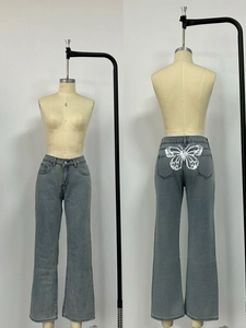 Dettaglio della stampa a farfalla sui jeans a vita alta grigio scuro lavati