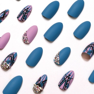 Faux ongles mats bleu et lilas avec motifs géométriques et strass étincelants