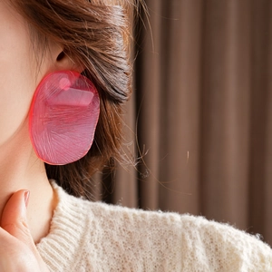 Close-up of pink oversized irregular translucent resin earrings with matte texture on model