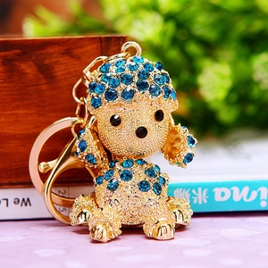 Macro shot of gold puppy keychain with blue rhinestones and textured metal details