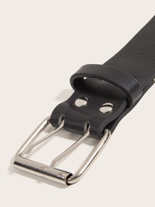 Close-up of a punk-style double-prong silver buckle on a premium black leather belt