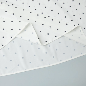 Detailed close-up of polka dot chiffon fabric with fine hem stitching and smooth texture