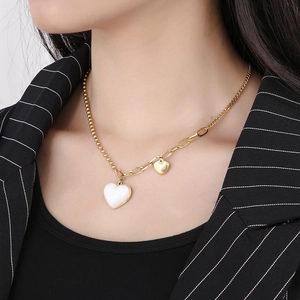 Detailed view of a gold double-layer necklace featuring white and gold heart pendants