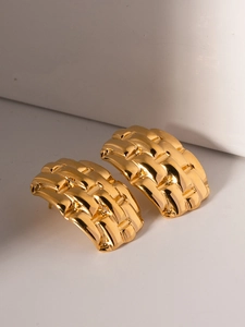 Detail of gold woven texture earrings on minimalist white geometric display stand