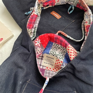 Close-up of corduroy tote bag lining with colorful patchwork patterns and brand labels