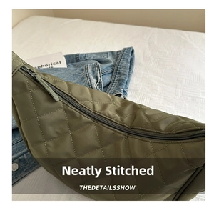 Close-up of army green nylon dumpling bag with diamond quilting and metal zipper