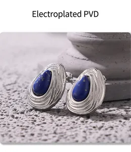 Vue macro de boucles d'oreilles goutte bleue plaquées PVD argent sur fond en pierre