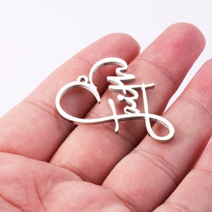 Silver stainless steel heart pendant featuring a faith word cutout held in a palm