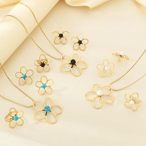 Parure bijoux fleurs dorées ajourées avec perles et turquoise sur tissu en soie