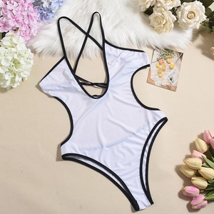 Flat lay of white one-piece swimsuit with black trim, waist cut-outs, and cross back straps