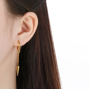 Detailed view of a gold stainless steel chain earring with spike drop worn on ear