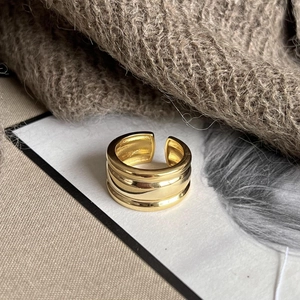 Modern wide three-layer wave gold ring with an adjustable open design on paper