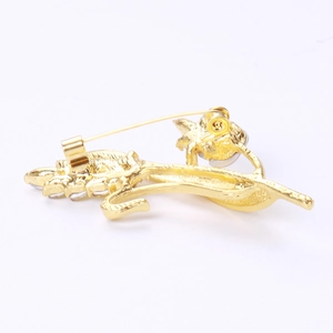 Detail view of the golden wheat brooch back showing secure safety pin and crystals