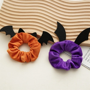 Detail of orange and purple velvet scrunchies with black bat wings for Halloween party