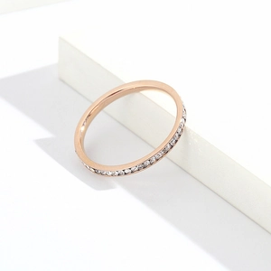 Close-up of minimalist rose gold eternity ring featuring a full circle of pavé crystals