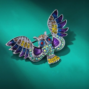 Détail de la broche hibou avec ailes en émail bleu et strass multicolores brillants