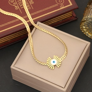 Nahaufnahme der goldenen Evil-Eye-Halskette mit blauem Anhänger auf Schmuckkästchen