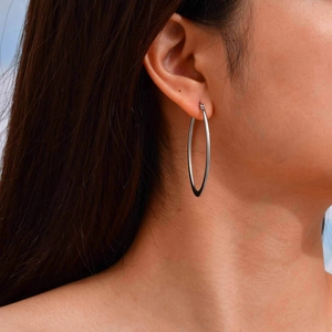 Minimalist silver hollow heart earrings worn by a model in a side profile view