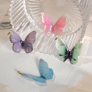Detail of DIY butterfly pendants in pink, purple, green and blue with gold foil gradient
