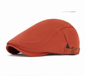 Close-up of orange cotton newsboy hat with adjustable metal buckle detail