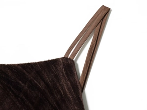 Close-up of deep brown velvet fabric texture with pleats and flat shoulder strap details