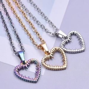 Detailed view of three heart pendants in gold, silver and rainbow with jagged edges