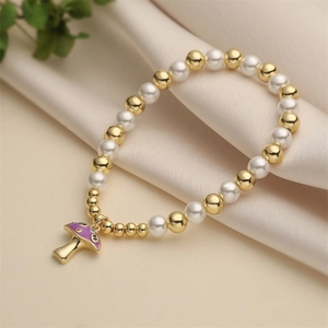 Chic beaded bracelet with gold metal beads, white pearls and a purple mushroom pendant