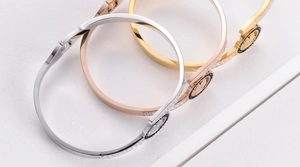 Dettaglio macro del bracciale con motivo a cigno e pavé di zirconi in oro e argento