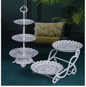 Macro shot of white tiered cupcake stands with intricate hollow floral patterns on rims