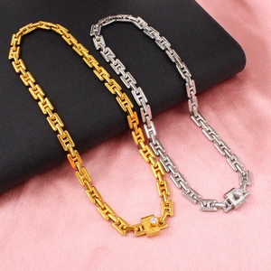 Gold and silver chunky H-link chain necklace set with gemstone buckle on pink satin
