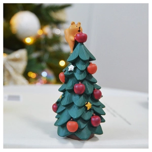 Detailed view of a green resin Christmas tree figurine with a cute orange bear topper