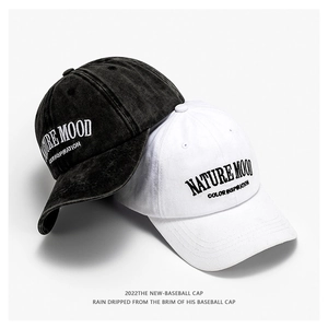Dettaglio del ricamo Nature Mood su cappellini in cotone lavato morbido in nero e bianco