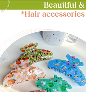 Detailed view of four acrylic hair claws with cherry and apple patterns for thick hair