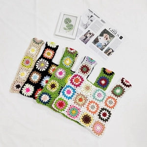 Detail of four handmade crochet granny square tote bags in various vintage colors