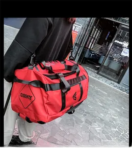 Detail of red large-capacity travel bag featuring durable nylon and reinforced black straps