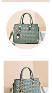 Detail of greyish-green quilted handbag with wave pattern, gold hardware and lucky charms