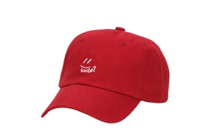Close-up of red baseball cap featuring high-quality white Smile embroidery and curved brim