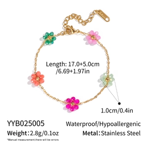 Detail view of a 17cm gold stainless steel bracelet with colorful floral beads and specs