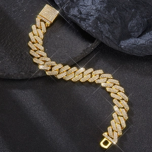 Macro detail of 14mm golden Cuban link chain with sparkling pavé zircons on rock base