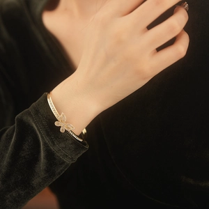 Close-up of gold butterfly cuff bracelet with pavé cubic zirconia on model's wrist