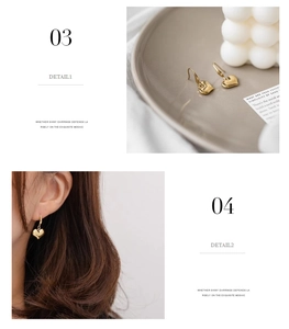 Detailed view of polished gold heart drop earrings and stylish model wearing look