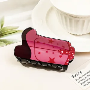 Detail of pink cowgirl boot hair claw clip with star patterns and acetate texture