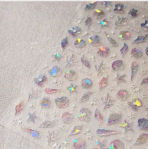 Detailed macro of holographic ocean nail stickers with 3D shells, starfish and coral