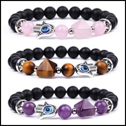 Detailed shot of amethyst and tiger eye bead bracelets with Hamsa Hand and evil eye charms